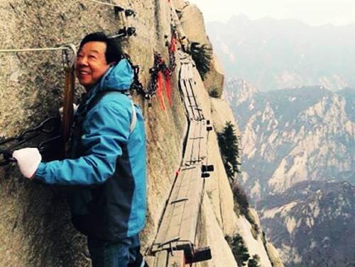 seorang bapak terlihat senang mendaki gunung Hua Tiongkok
